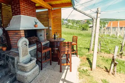 a patio with a fireplace and a table and chairs at Zidanica Bahor in Črnomelj