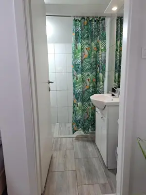 a bathroom with a shower curtain and a sink at Koča Martuljek in Gozd Martuljek