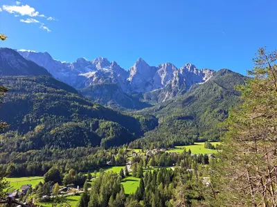 a view of a valley with mountains in the background at Koča Martuljek in Gozd Martuljek