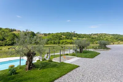 a gravel driveway with trees and a swimming pool at Kamp Brda Camping and rooms in Kojsko