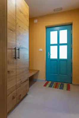 a blue door in a room with wooden cabinets at Kamp Brda Camping and rooms in Kojsko