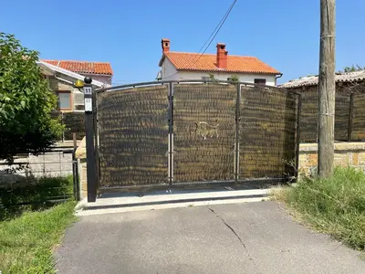 a gate in a fence in front of a house at Villa Sanela in Pobegi