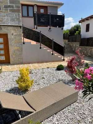 a house with a balcony and a garden with flowers at Villa Sanela in Pobegi