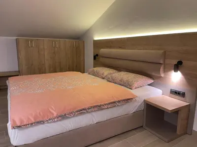 a bedroom with a bed with an orange comforter at Villa Sanela in Pobegi
