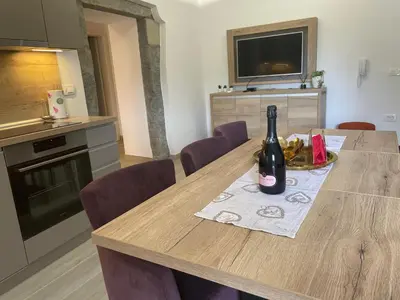 a kitchen with a table with a bottle of wine on it at Villa Sanela in Pobegi