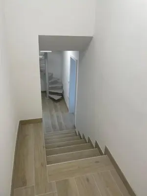 a staircase in a room with white walls and wooden floors at Villa Sanela in Pobegi