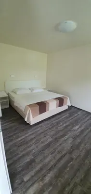 a bed in a bedroom with a wooden floor at Gostilna s prenočišči Pri Janezu in Zgornja Ložnica