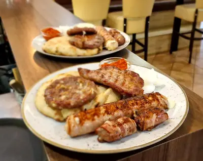 two plates of food on a table with sausage and bread at Gostilna s prenočišči Pri Janezu in Zgornja Ložnica