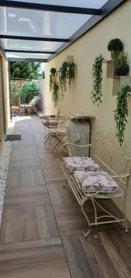 a patio with chairs and tables and plants at Apartma Archy in Moravske Toplice