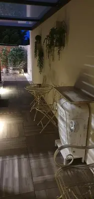 a room with a table and chairs on a patio at Apartma Archy in Moravske Toplice