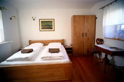 a bedroom with a wooden bed and a desk at Sleeping in Village in Svečina