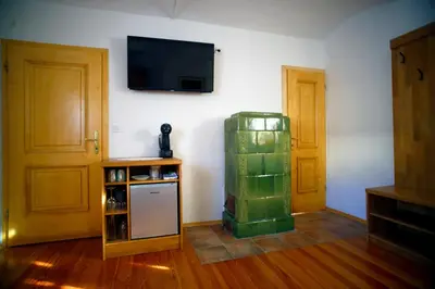 a room with a refrigerator and a tv on a wall at Sleeping in Village in Svečina