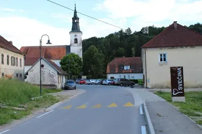 an empty street in a small town with a church at Sleeping in Village in Svečina