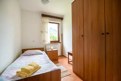 a bedroom with a bed and a wooden cabinet at Holiday apartment Pika in Bovec