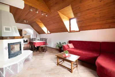 a living room with a red couch and a fireplace at Holiday apartment Pika in Bovec
