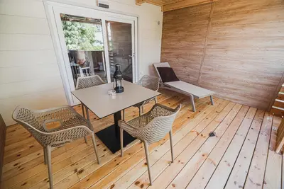 a room with a table and chairs on a wooden floor at Premium Mobile Tree House with Thermal Riviera Tickets in Čatež ob Savi