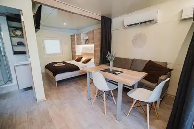 a bedroom with a bed and a table and chairs at Premium Mobile Tree House with Thermal Riviera Tickets in Čatež ob Savi