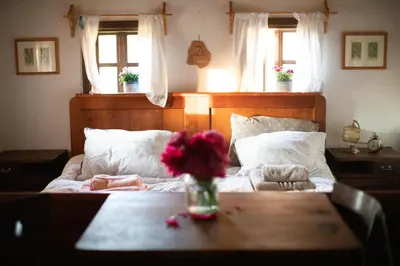 a bedroom with a bed with a vase of flowers on a table at HIS-a za 2 in Dragatuš