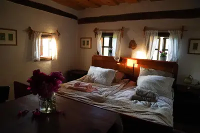 a bed with a vase of flowers on a table at HIS-a za 2 in Dragatuš