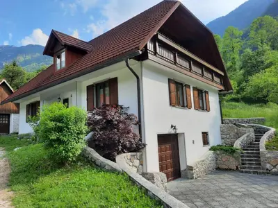 a small white house with a brown roof at Počitniško stanovanje PLANJA in Soča