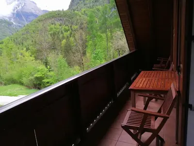 a balcony with a table and a view of a mountain at Počitniško stanovanje PLANJA in Soča