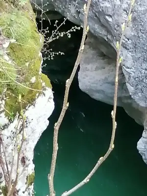 a pool of emerald green water in a cave at Počitniško stanovanje PLANJA in Soča