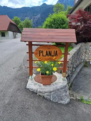a bench with a sign that reads planka at Počitniško stanovanje PLANJA in Soča
