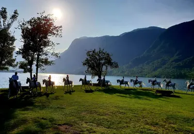 a group of people riding horses on the water at Hiša Lojz in Žaga