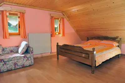 a bedroom with a bed and a couch and windows at Turistična kmetija Kunstek in Rogatec
