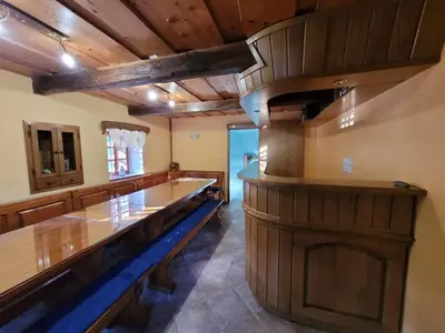 a large room with a large wooden bar in a building at Turistična kmetija Kunstek in Rogatec