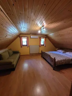 a room with a bed and a couch in a attic at Turistična kmetija Kunstek in Rogatec
