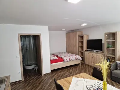 a small bedroom with a bed and a tv at Apartma Ribnica na Pohorju in Ribnica na Pohorju