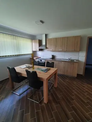 a kitchen with a wooden table and chairs in a room at Apartma Ribnica na Pohorju in Ribnica na Pohorju