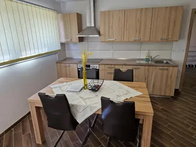 a kitchen with a wooden table and black chairs at Apartma Ribnica na Pohorju in Ribnica na Pohorju
