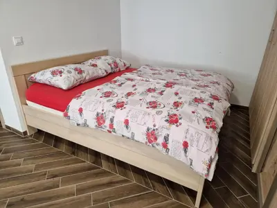 a bed with a red and white quilt on it at Apartma Ribnica na Pohorju in Ribnica na Pohorju