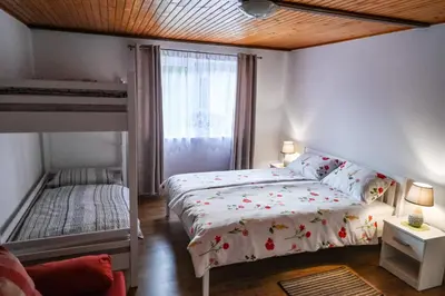 a small bedroom with a bed and a window at Sobe - rooms R&K in Bohinj
