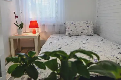 a small bedroom with a bed and a table with a lamp at Sobe - rooms R&K in Bohinj