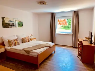 a bedroom with a bed and a desk and a window at Zelena Oaza in Zgornja Kungota
