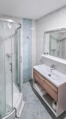 a white bathroom with a sink and a shower at Zelena Oaza in Zgornja Kungota