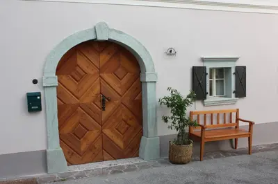 a wooden door with a bench next to a building at MEŽNARIJA Radovljica in Radovljica