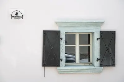 a window on a white building with black shutters at MEŽNARIJA Radovljica in Radovljica