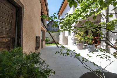 an alley between two buildings with potted plants at MEŽNARIJA Radovljica in Radovljica