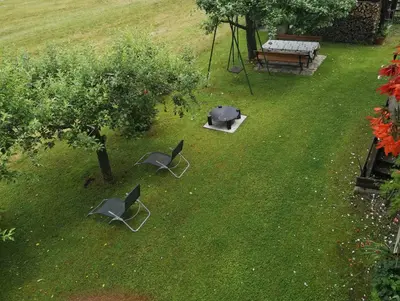 two chairs and a table and a bench in a yard at Apartmaji Preželj in Bohinj