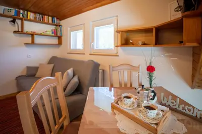 a living room with a table and a couch at Apartmaji Preželj in Bohinj