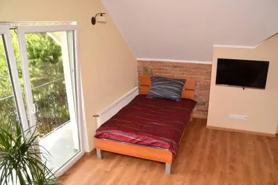 a room with a couch with a tv and a window at Villam Apartment in Maribor