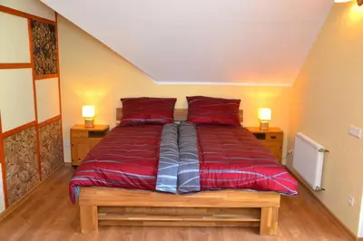 a large bed with red sheets in a room at Villam Apartment in Maribor