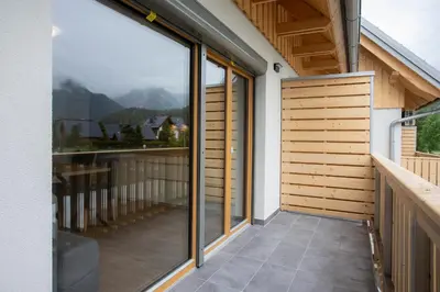 a balcony with sliding glass doors on a house at Apartment Bistra Kranjska Gora in Kranjska Gora