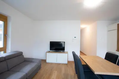 a living room with a couch and a table with a television at Apartment Bistra Kranjska Gora in Kranjska Gora