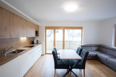 a kitchen with a table and chairs and a couch at Apartment Bistra Kranjska Gora in Kranjska Gora