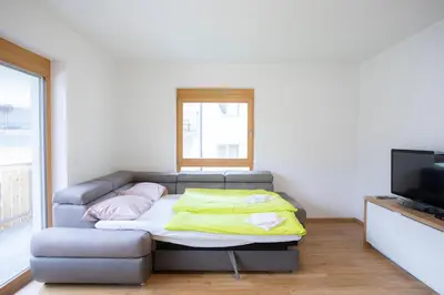 a living room with a couch and a television at Apartment Bistra Kranjska Gora in Kranjska Gora